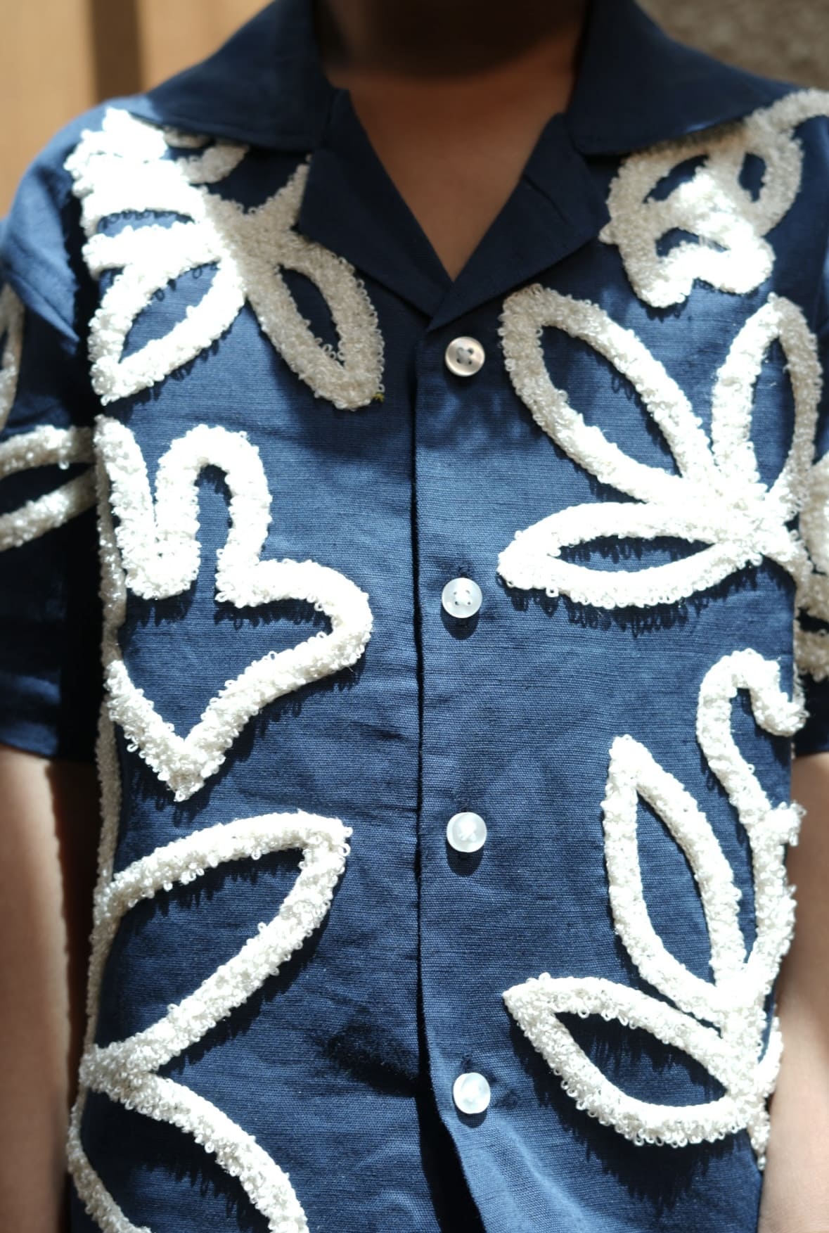 Blue shirt with white floral patterns on a blurred background