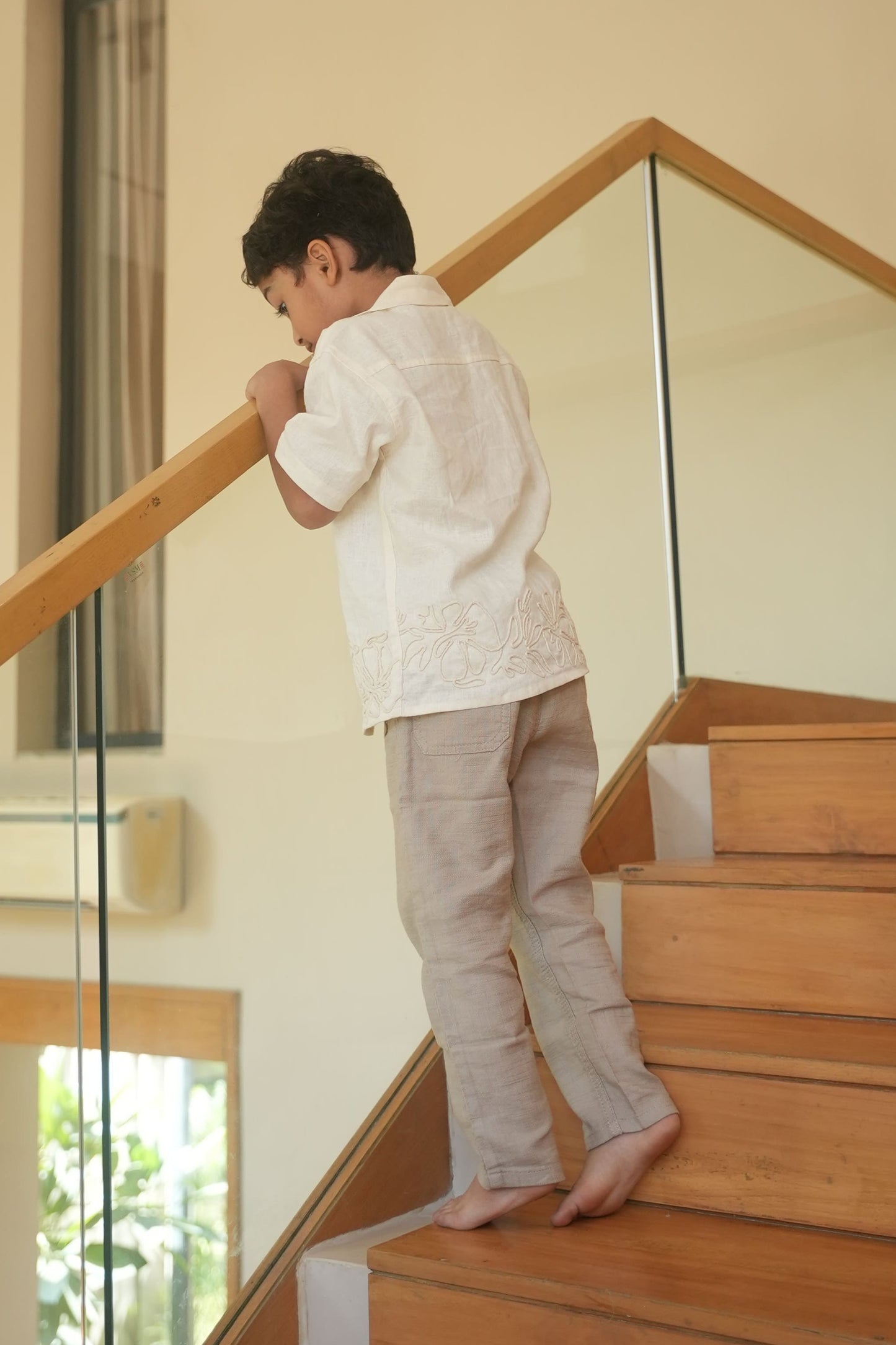 Child standing on a wooden staircase indoors