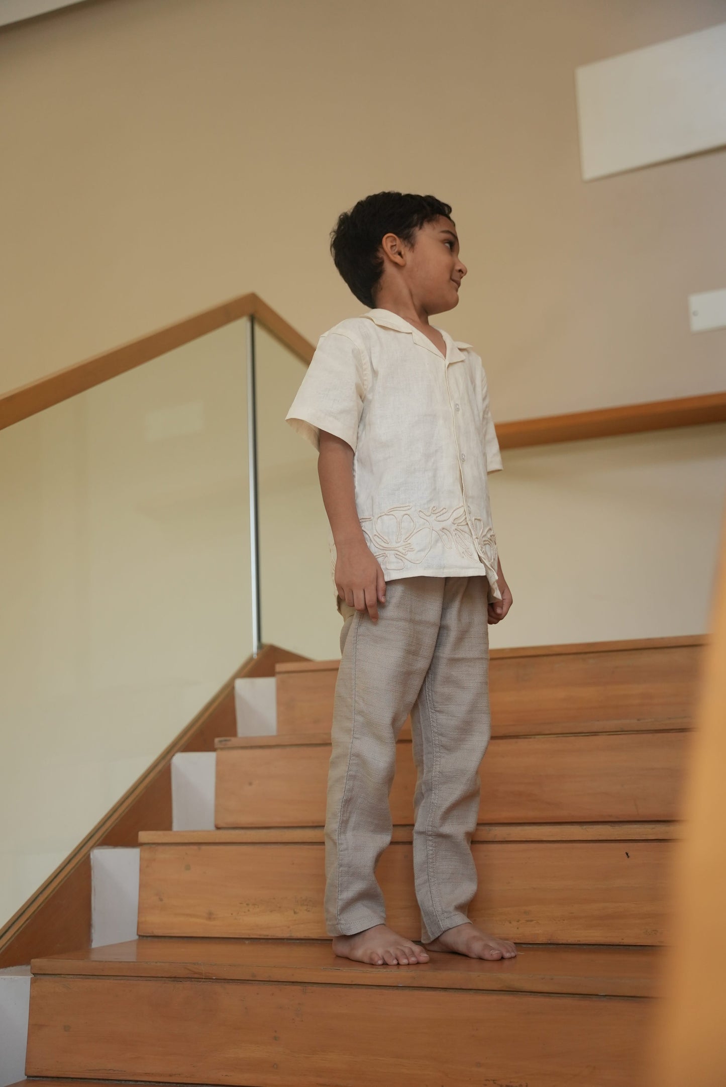 Person standing on a wooden staircase with a neutral wall background
