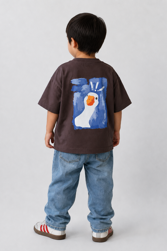Child wearing a brown t-shirt with a colorful graphic on the back, standing against a plain background.