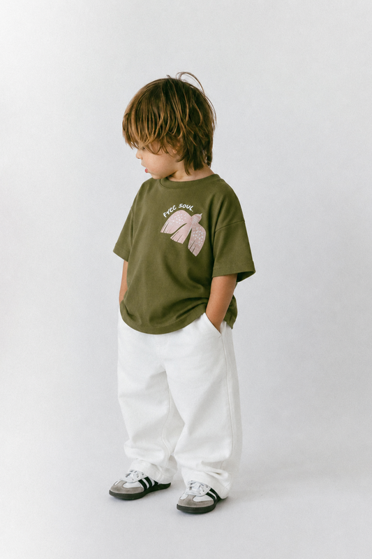 Child wearing an olive green t-shirt with a graphic design on a white background