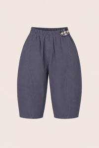 Blue kids pants with a plaid patch on a beige background
