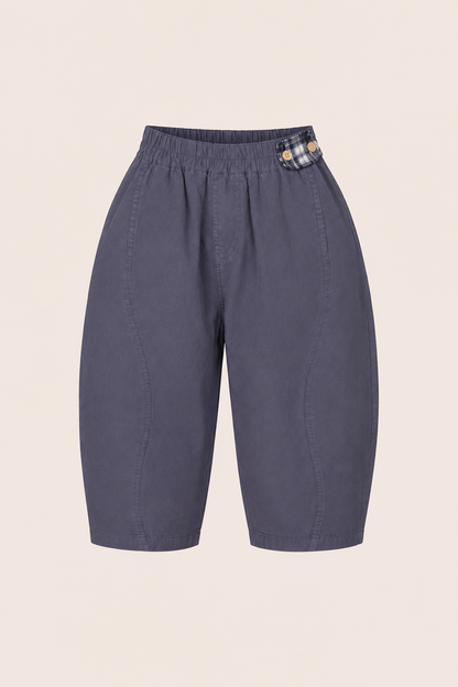 Blue kids pants with a plaid patch on a beige background
