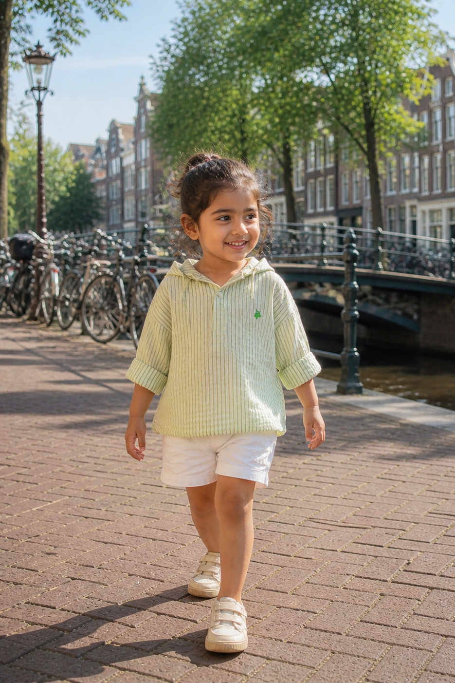 Child walking along a canal with bicycles and buildings in the background