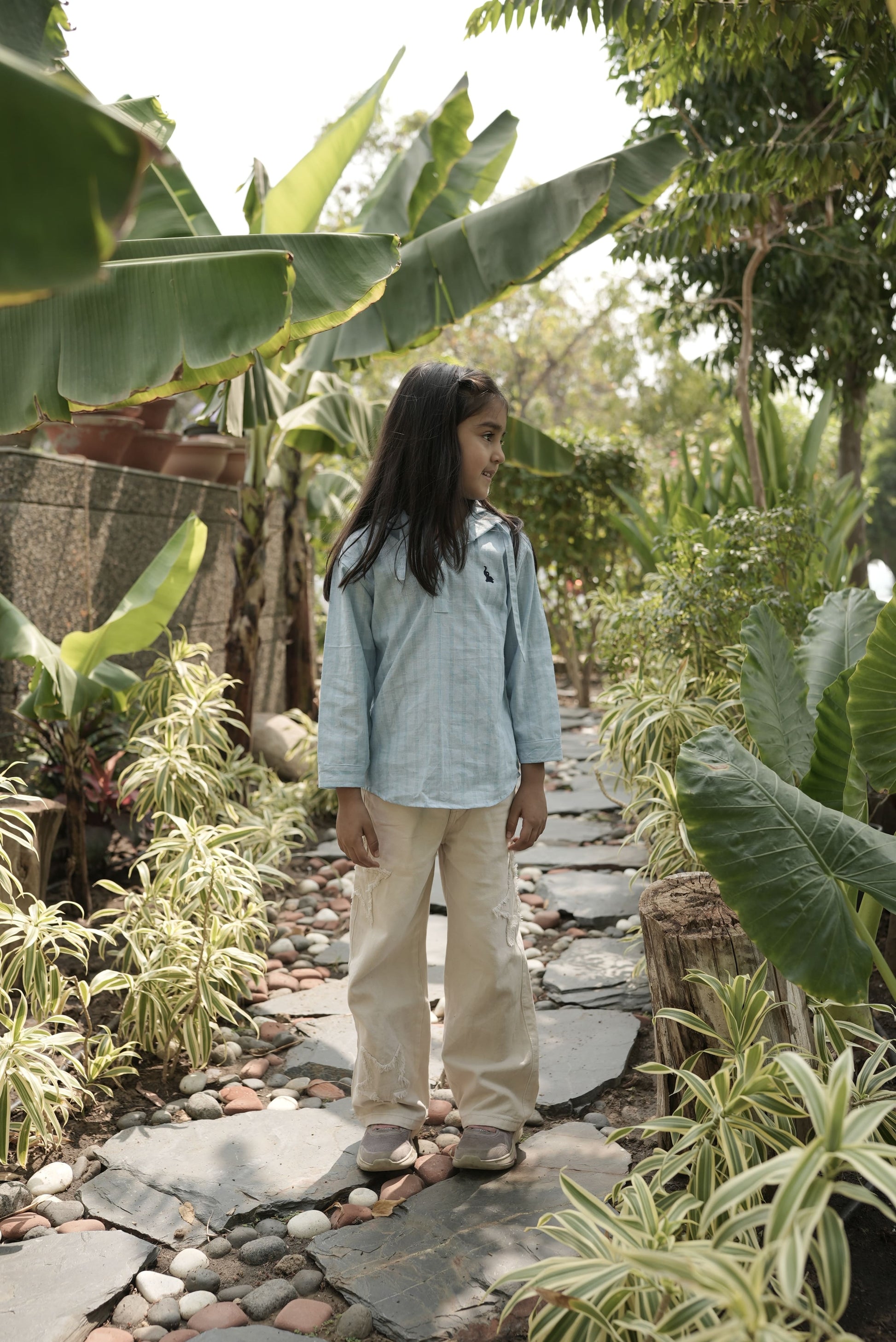 Person walking on a stone path surrounded by greenery