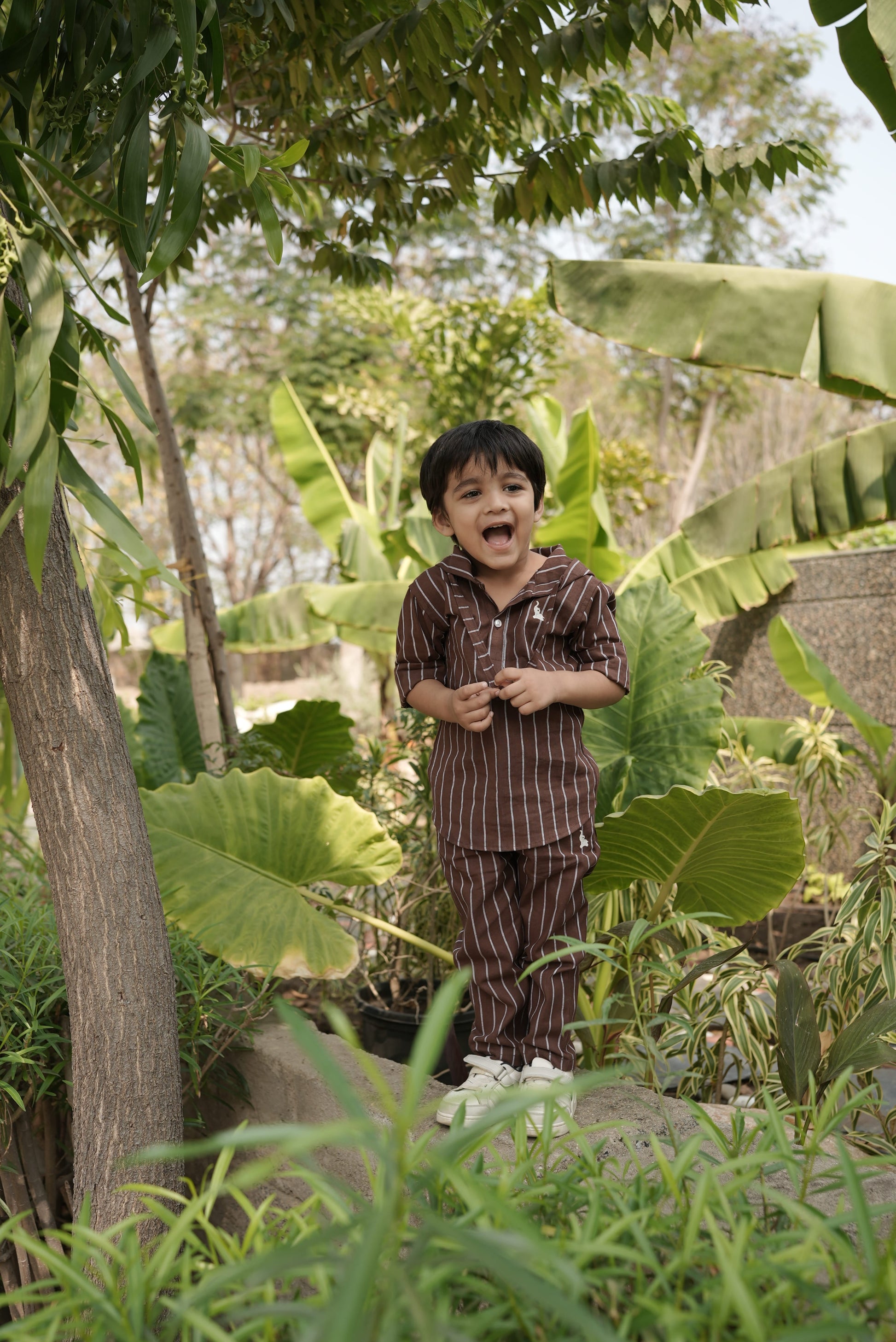 Person standing among lush green foliage