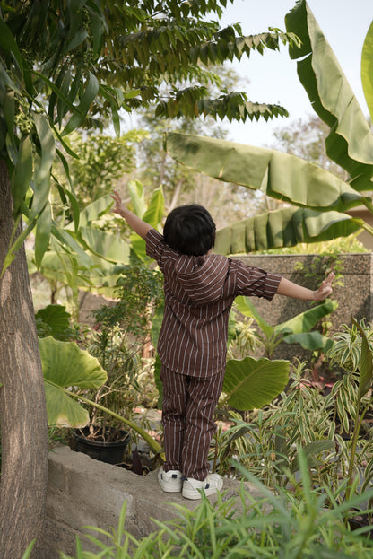kid standing in a garden with large green leaves and plants