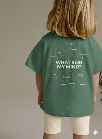 Child wearing a green t-shirt with 'What's on My Mind?' text and diagram on the back.