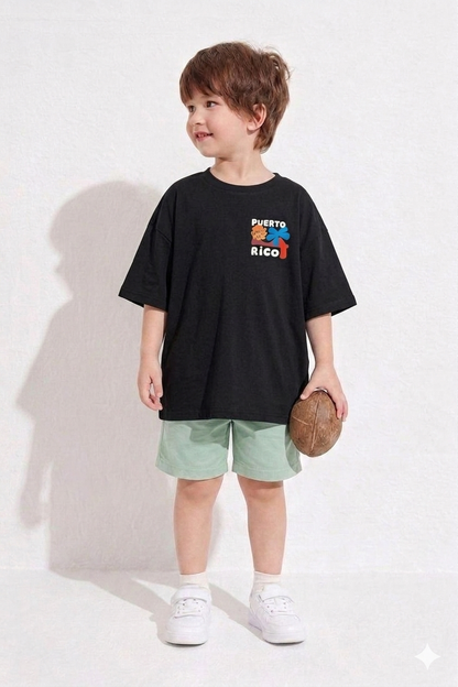 Child wearing a black oversized t-shirt with 'Puerto Rico' print, light green shorts, and white sneakers on a white background.