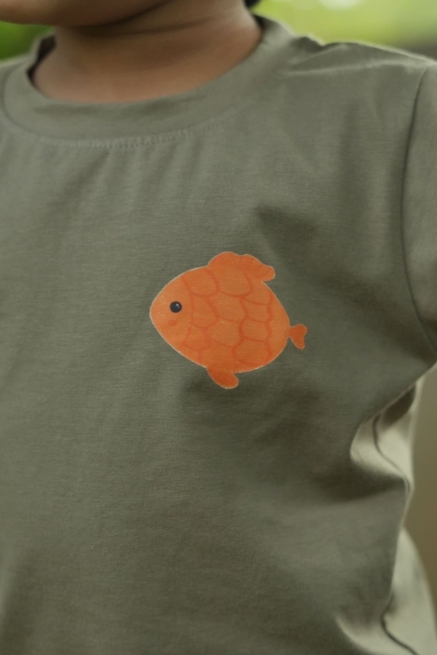 Orange fish patch on a green shirt
