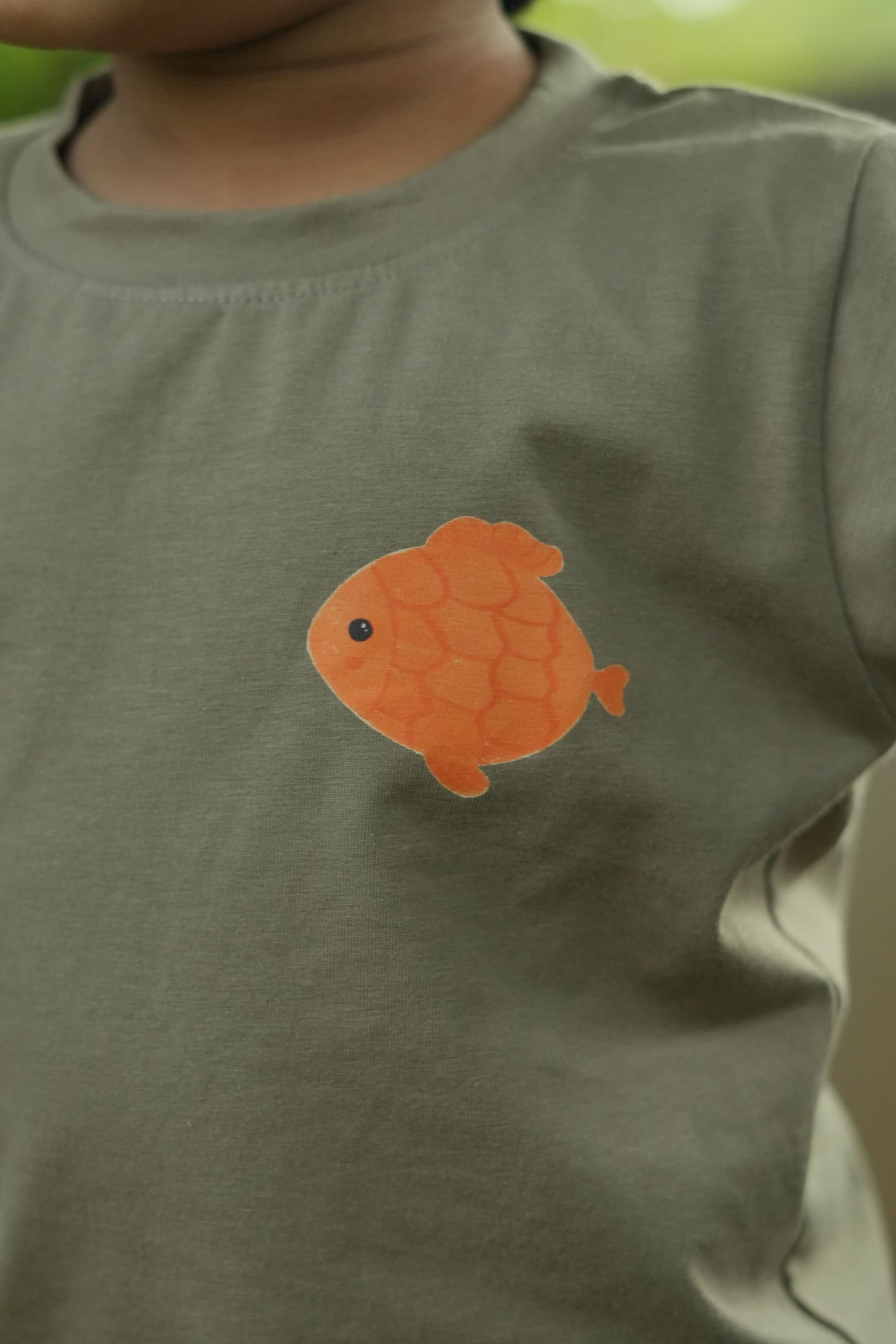 Orange fish patch on a green shirt