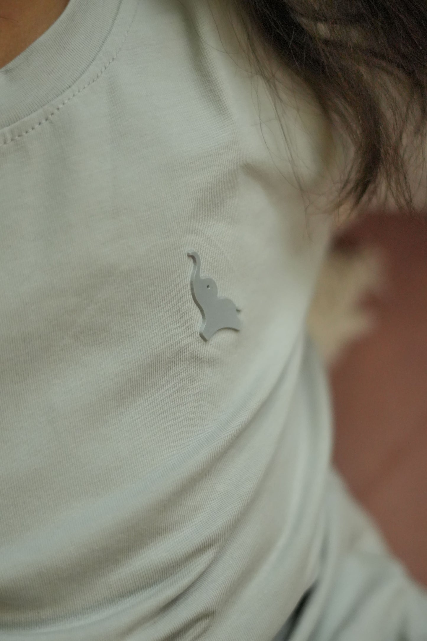 Close-up of a white shirt with a small logo on a blurred background
