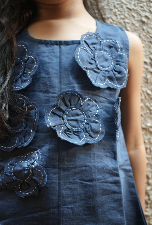 Blue dress with floral embellishments on a textured background