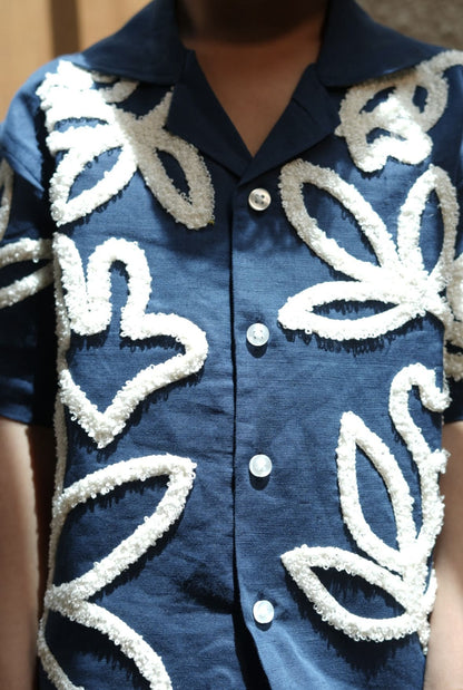 Blue shirt with white floral patterns on a blurred background