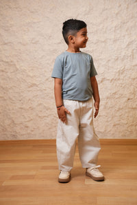Person standing on a wooden floor with a textured beige wall in the background