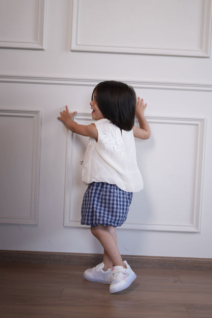 Person taking a mirror selfie in a room with white walls and wooden floor.