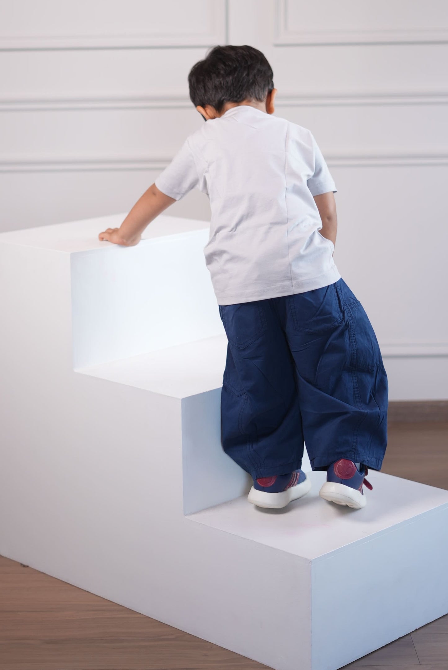 Person standing on a white platform with a white wall in the background