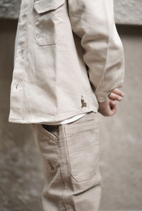 Beige jacket and pants worn by a person against a neutral background