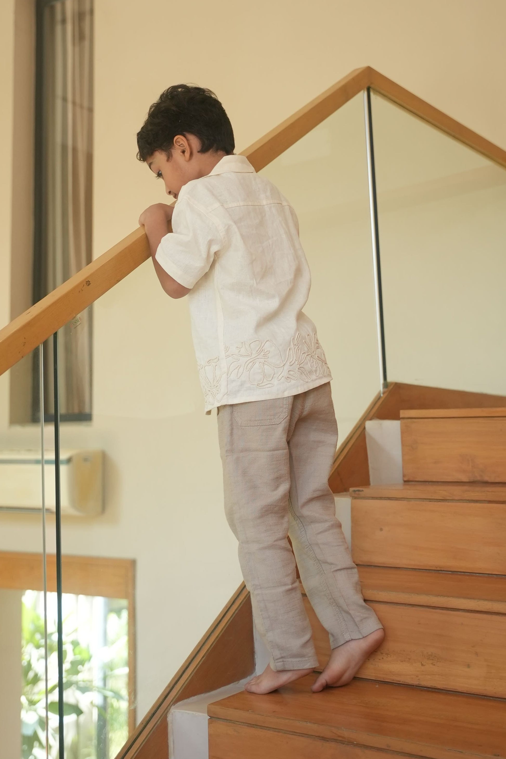 Child standing on a wooden staircase indoors