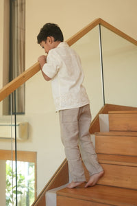 Child standing on a wooden staircase indoors