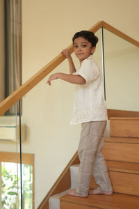 Child standing on a staircase with a glass balustrade