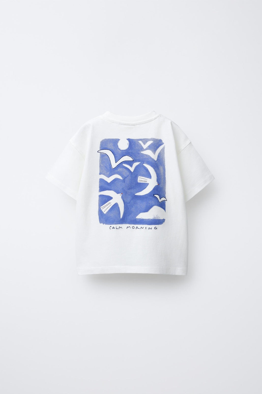 White t-shirt with blue bird pattern on a white background