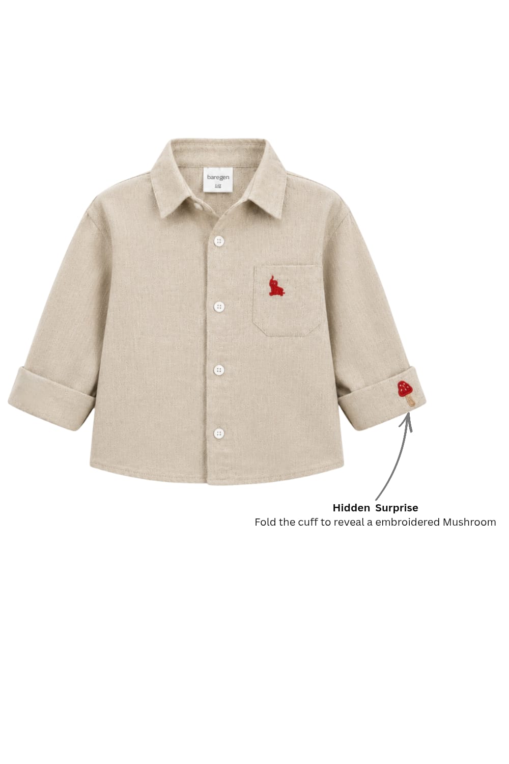 A beige long-sleeve children's button-up shirt with a chest pocket featuring a small red embroidered rabbit, shown on a white background with a text callout about a hidden surprise cuff embroidery.