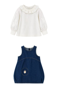 Two children's dresses shown on a plain white background: a white long-sleeve blouse with a ruffled collar and puff sleeves, and a navy sleeveless denim dress with a front patch pocket.
