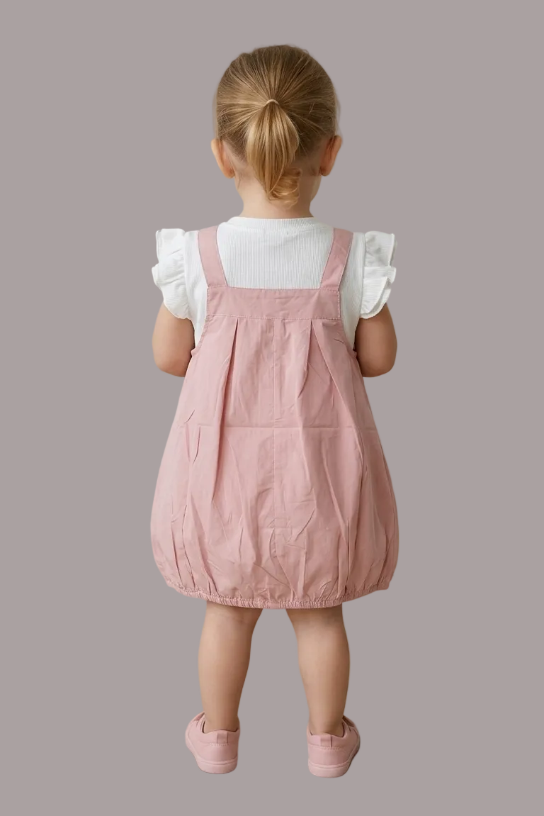 Child wearing a pink dress standing on a tiled floor